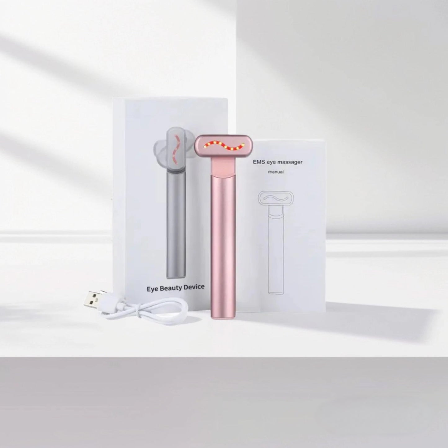 Pink 4-in-1 red light therapy eye massager for reducing dark circles and puffiness.