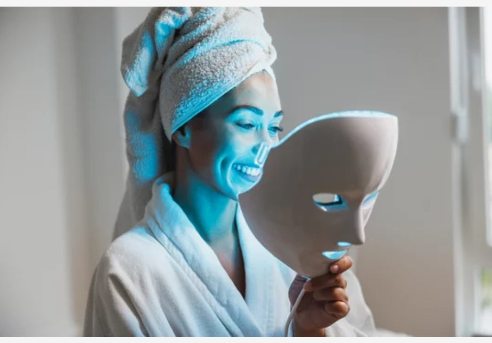 Model holding a 7-color LED face mask, demonstrating its sleek and lightweight design for home skincare. 