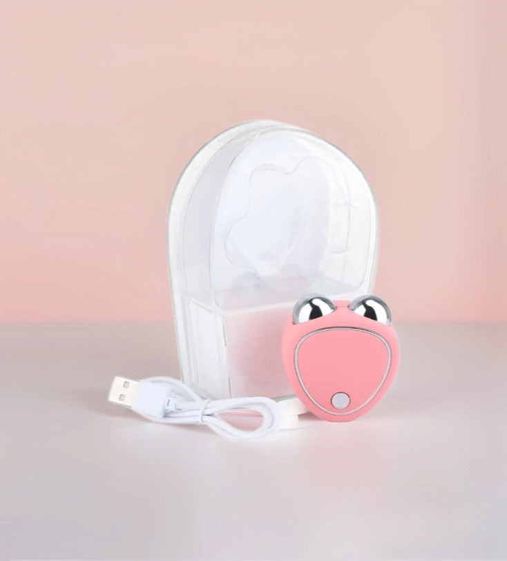 Portable pink electric facelift massager for skin sculpting and firming. 